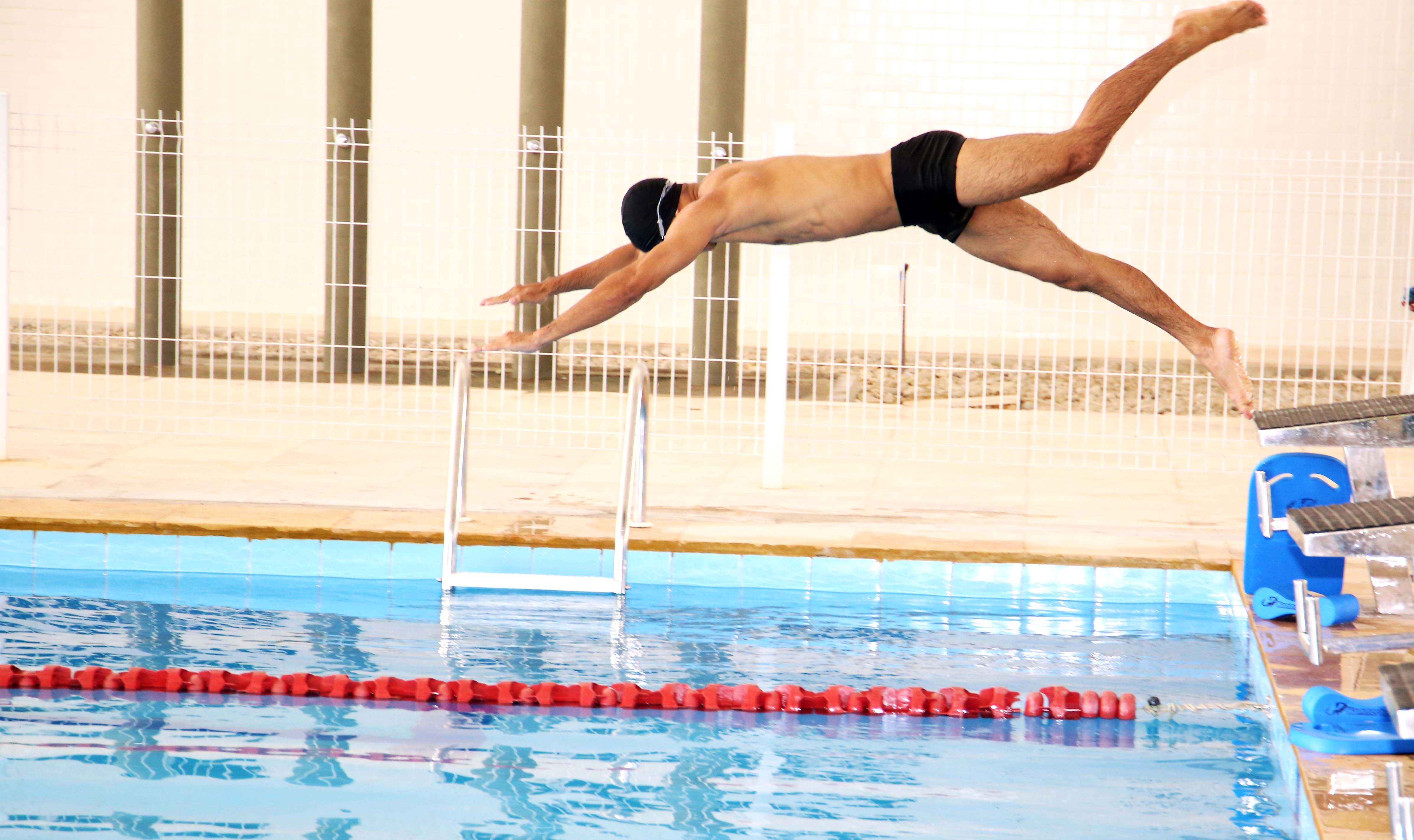 um nadador salta em uma piscina